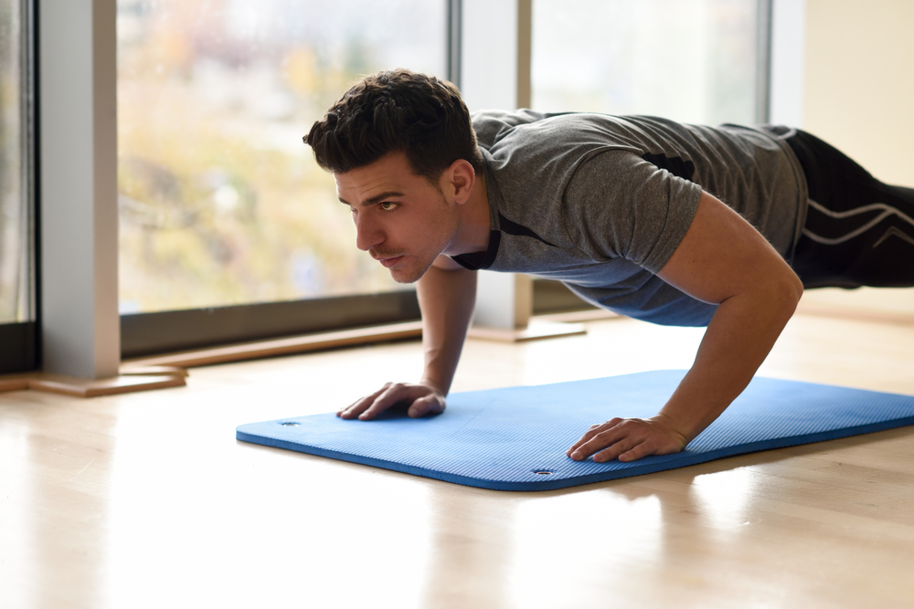 "A man performing push-ups with proper form, strengthening his chest, triceps, and core muscles