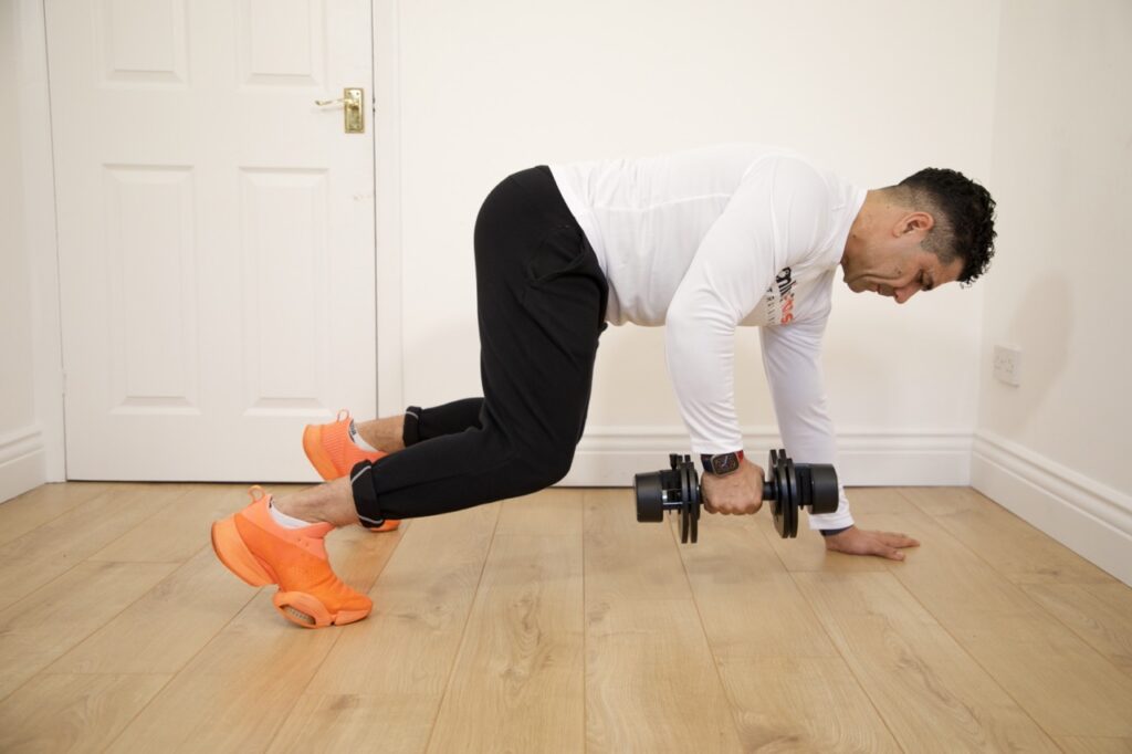 Man doing dumbbell exercises indoors for strength training and fitness