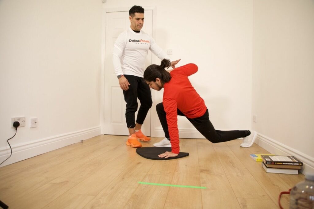 Personal trainer assisting client with strength training exercise